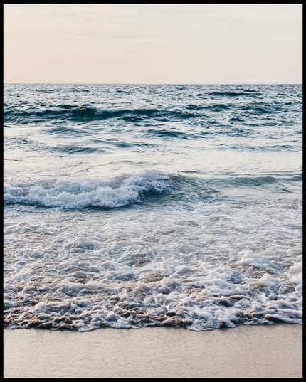 Leinwandbild von schaumigen Wellen am Strand.