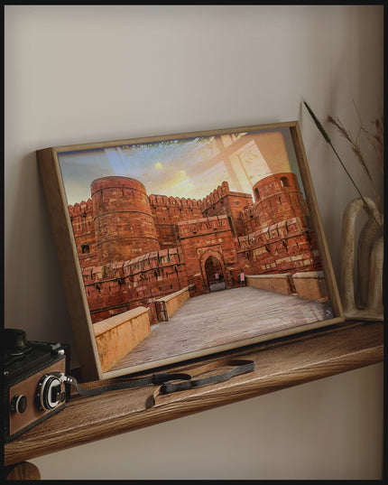 Ein gerahmtes Poster vom Agra Fort in Indien bei Sonnenuntergang, auf einem Holzregal an die Wand angelehnt