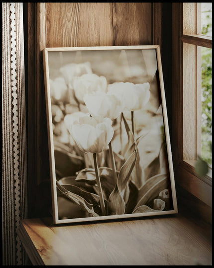 Ein gerahmtes Poster von mehreren Tulpen mit Sepiafilter, vor einem Fenster an die Wand angelehnt